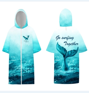 Detail of hooded surfing poncho with zipper and ocean gradient whale print