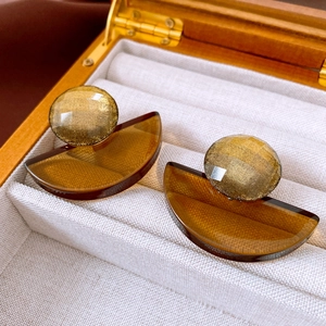 Detailed close-up of amber resin earrings with gold flakes displayed in a jewelry box