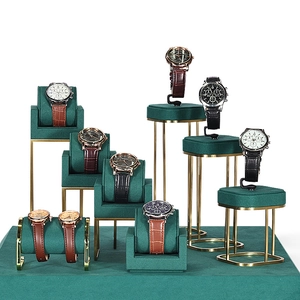Green velvet and gold metal watch display stands set for retail storefront showcase