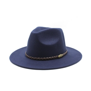 Macro shot of dark blue wool fedora featuring a braided leather band and metal emblem