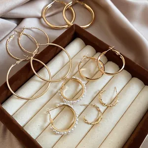 Goldene Creolen-Set mit glatten, texturierten und Perlen-Stilen in einer Schmuckschatulle