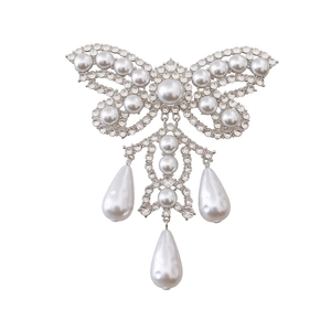 Vintage butterfly pearl brooch with rhinestones and tassel pendants on white background