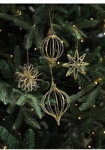 Close-up of four glittery gold Christmas ornaments hanging on a festive green tree