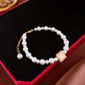 Détail d'un bracelet en perles avec accent zircon dans un écrin en velours noir