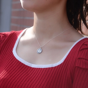 Vintage S925 sterling silver queen coin pendant necklace worn by a model on a red background
