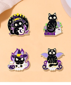 Close-up of four black cat enamel pins with magic potion, crystal ball, and skull details