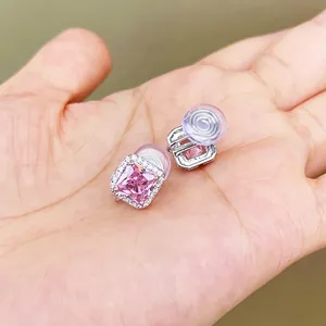 Detailed view of square pink gemstone stud earrings with halo setting and silicone pad