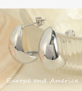 Macro detail of chunky hollow silver hoop earrings with a polished mirror finish