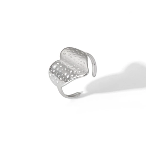 Detailed macro of silver heart ring featuring unique hammered texture and adjustable open band