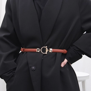 Slim dark brown leather belt with gold metal ring buckle on a black blazer jacket