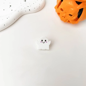Detail view of a white ghost hair claw clip with a cute smile face for Halloween