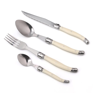 Detailed view of 4-piece stainless steel cutlery set with beige ABS handles and rivets