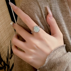 Detailed view of silver ring featuring a green gourd gemstone and pavé-set diamonds
