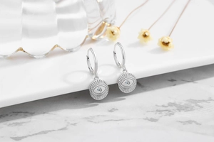 Macro detail of S925 sterling silver evil eye earrings with zircon inlay and ray texture