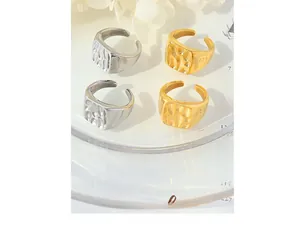 Close-up of hammered gold and silver open rings with geometric square design texture