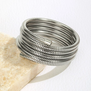 Close-up of multi-layer silver spring bracelet with fine texture on stone surface