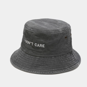 Close-up of I DON'T CARE white embroidery on charcoal grey washed canvas bucket hat
