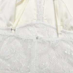 Détail de dentelle blanche sur le dos d'une robe dos nu avec fermeture éclair invisible