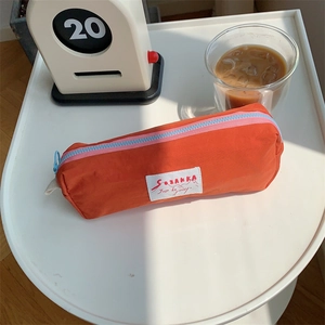 Orange macaron pencil case on desk with calendar and coffee for study scene