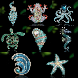 Macro shot of assorted sea animal brooches with colorful rhinestones on black background