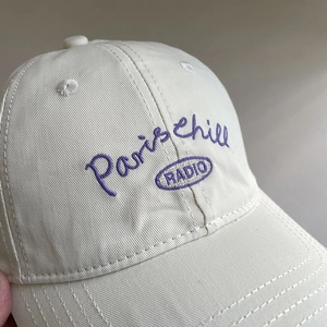 Cream soft top cotton baseball cap with purple Paris Chill embroidery for sun protection