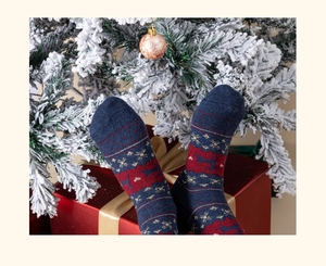 Donkerblauwe kerstsokken van wol met rendierpatronen in een feestelijke cadeauzetting