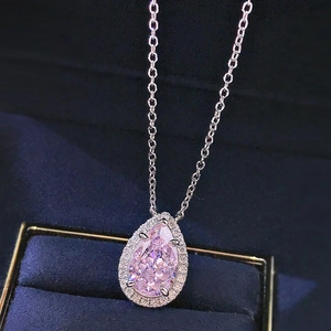 Elegant pear cut pink zircon pendant necklace with diamond halo on blue velvet