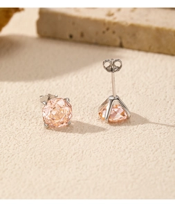 Close-up of champagne faceted gemstone earrings with four-prong silver setting
