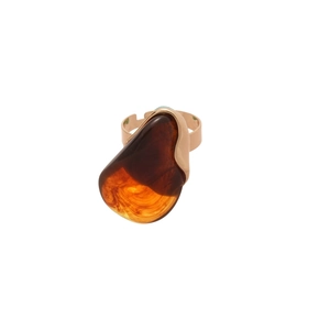 Bague ovale en résine à texture ambrée vintage et anneau doré sur fond blanc
