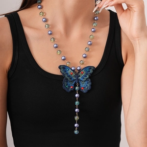 Detail of embroidered blue butterfly pendant with purple and green beads on necklace