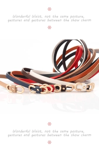 Close-up of slim women's PU leather belts with decorative gold metal figure-eight buckles