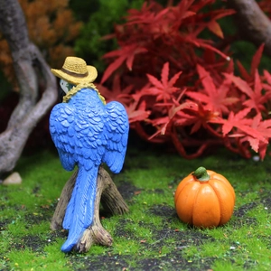 Blue parrot figurine with straw hat and mini pumpkin for autumn garden micro landscape