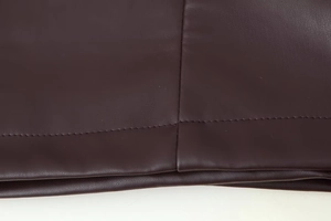 Detail shot of high-quality dark brown PU leather jacket showing sewing craftsmanship