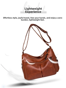 Detail showing lightweight brown faux leather shoulder bag with multiple zippers and feathers