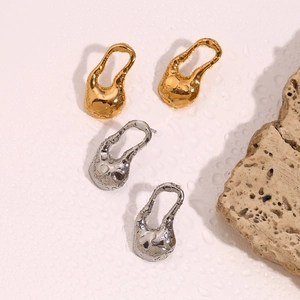 Vue détaillée de boucles d'oreilles gouttes creuses irrégulières en fini or et argent