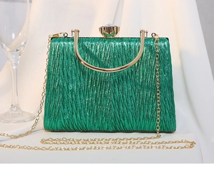 Detail of green pleated evening bag with metallic finish, rhinestone clasp and gold handle