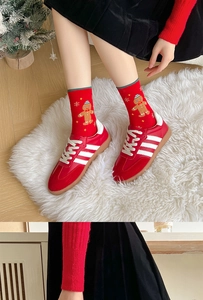Close-up of red Christmas socks with gingerbread man patterns worn with red sneakers