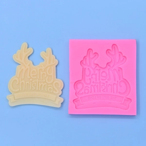Pink silicone mold for Christmas baking with Merry Christmas text and reindeer antlers