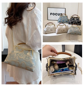 Detail view of vintage silk handbag with floral embroidery, wooden handle and metal chain