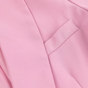 Dettaglio ravvicinato della cucitura della tasca e del tessuto in twill rosa del blazer