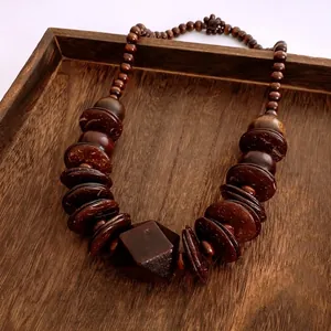 Ethnic style necklace with dark coconut shell beads and geometric wood pendant design