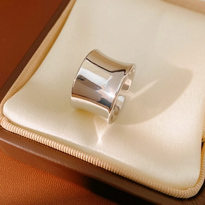 Macro detail of a wide minimalist open ring with polished concave surface on satin