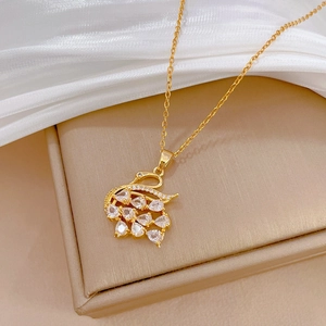 Close-up of a swan pendant with sparkling white zircons on a soft silk background