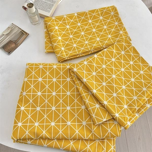 Detailed view of yellow geometric cotton linen tablecloth with triangle grid pattern