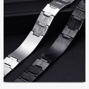 Close-up of black and silver stainless steel geometric link bracelets on dark texture