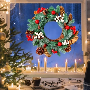 Detailed view of a lush Christmas wreath with pine cones and berries against a cozy window