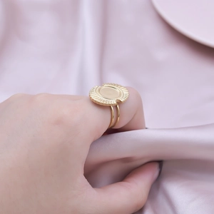 Macro shot of double-band gold stainless steel ring with sunburst disc on silk