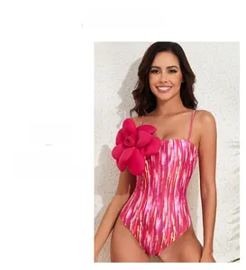 Detail of pink one-piece swimsuit featuring 3D floral accent and abstract prints