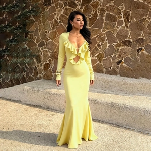 Detalle del escote en V con volantes y dobladillo de sirena en un vestido largo amarillo