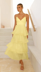 Detail of light yellow tiered cake dress showing layered organza fabric and flowing ruffles